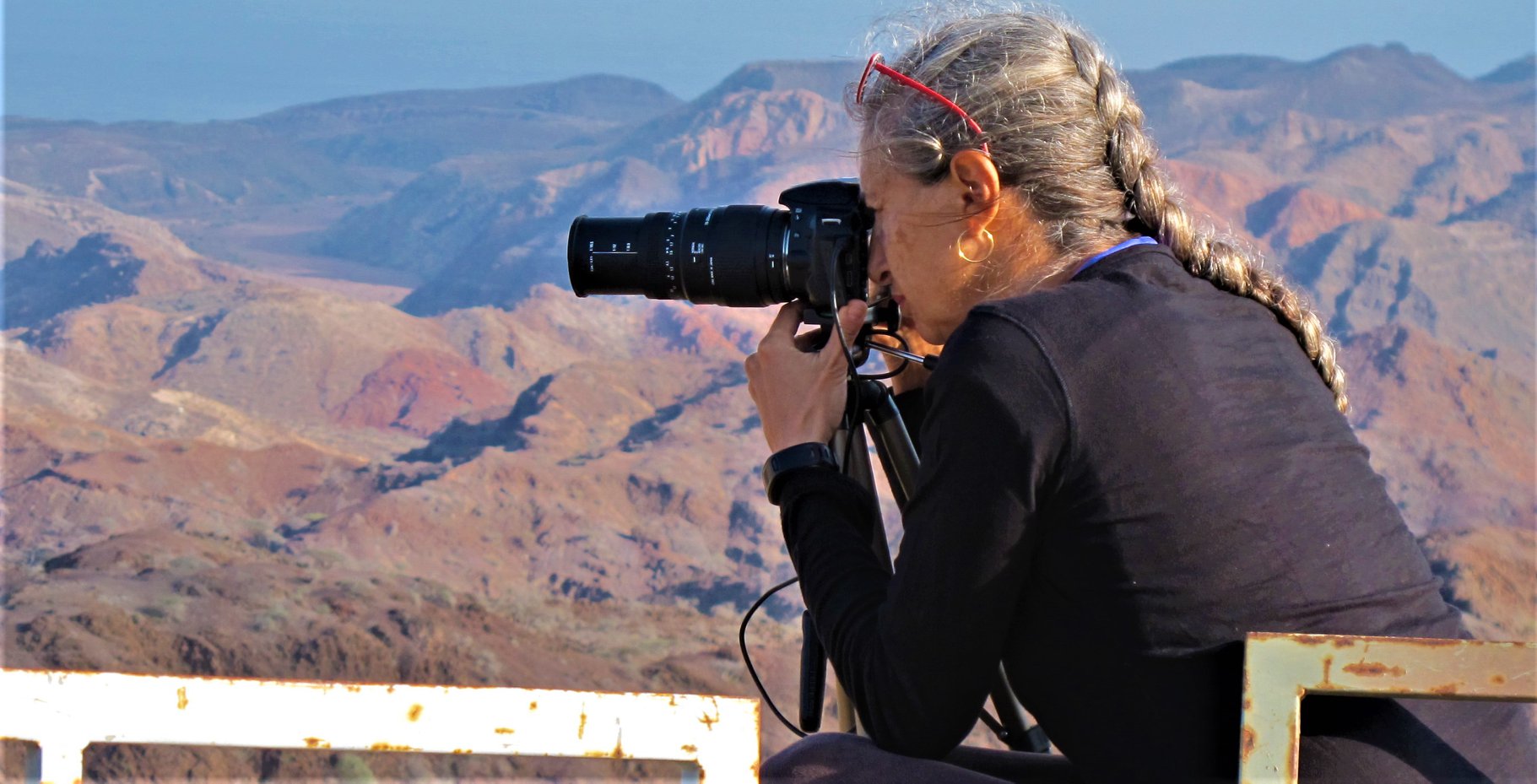 Une femme prend en photo les paysages depuis Arta la maison des randonneurs