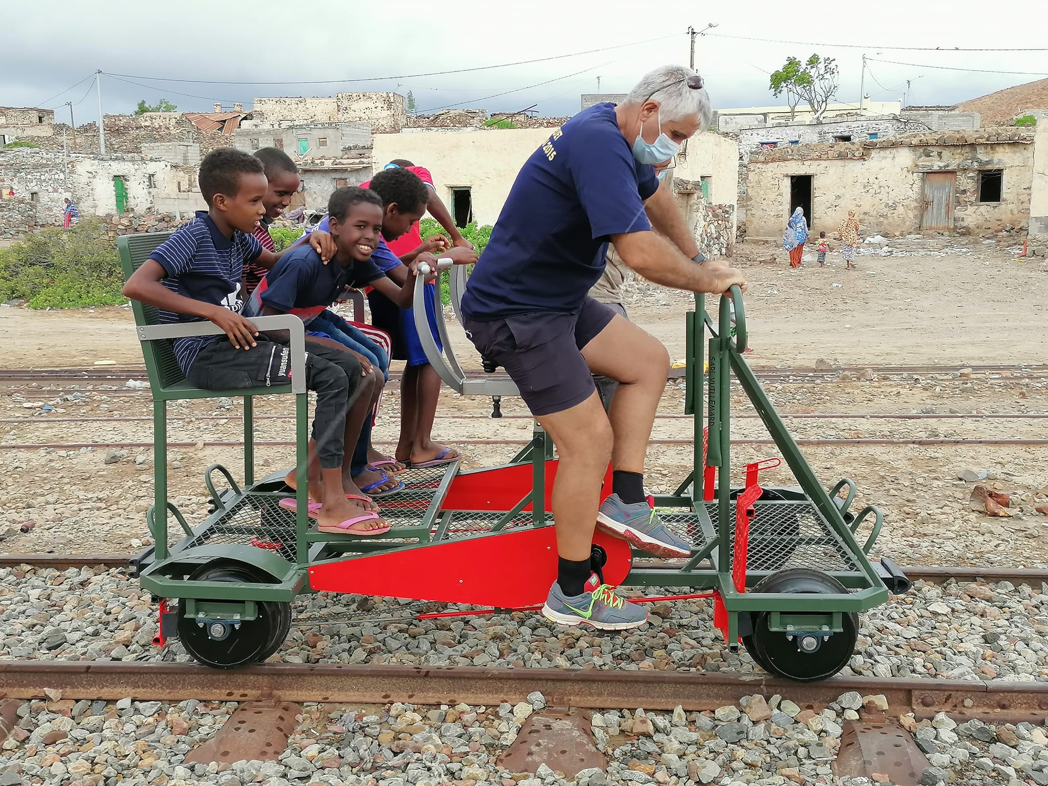 Un groupe d'enfants et un adulte en train de profiter d'une balade en vélorail sur une ancienne voie ferrée à Dasbiyo, dans la région d'Ali Sabieh.